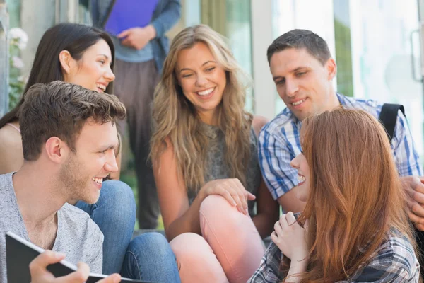 Happy students looking at book outside on campus — Stock Photo, Image