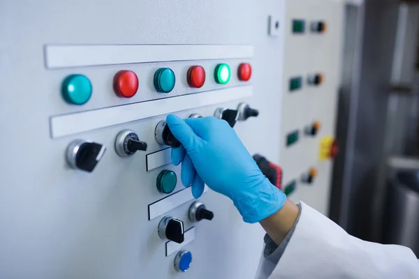 Hand with gloves turning buttons of the machine — Stock Photo, Image