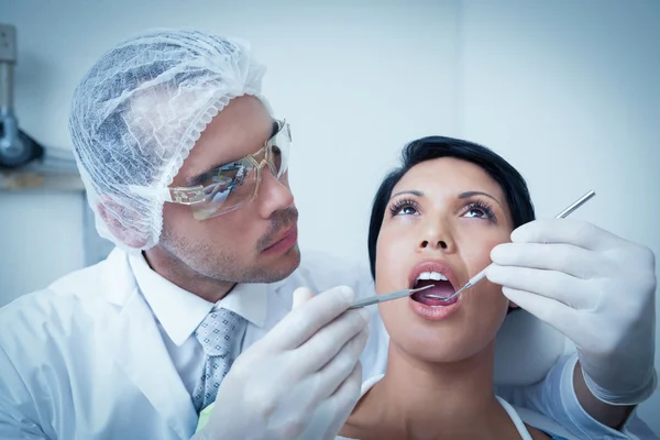 Dentista masculino examinando los dientes de las mujeres — Foto de Stock