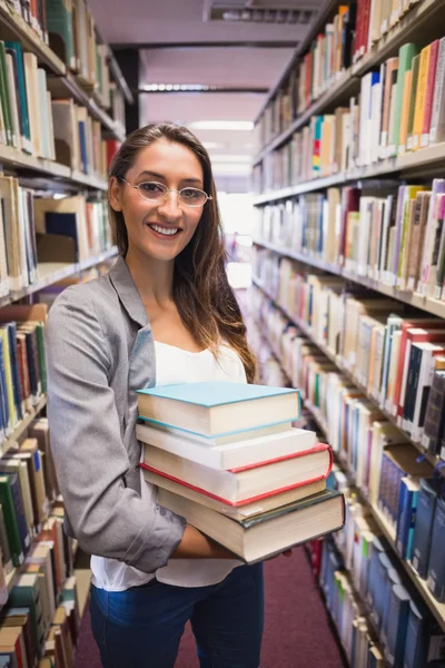 Estudante bonito sorrindo para a câmera na biblioteca — Fotografia de Stock