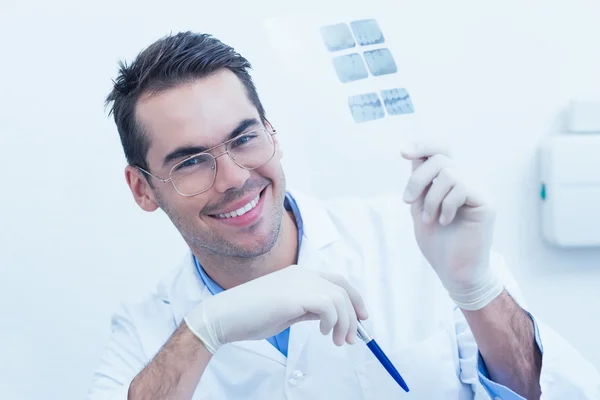 Улыбающийся мужчина-дантист держит на рентгене — стоковое фото