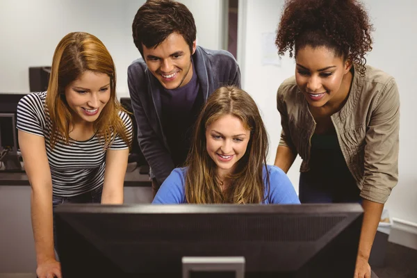 Lachende studenten zit aan bureau computer samen gebruiken — Stockfoto