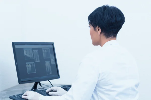 Dentist looking at x-ray on computer — Stock Photo, Image