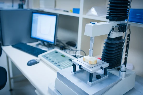 Machine analysing slice of bread with computer — Stock Photo, Image