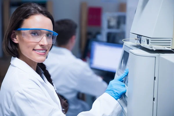 Lachende jonge scheikundige gebruik van de machine — Stockfoto