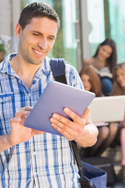 Szczęśliwy uczeń za pomocą jego komputera typu tablet na kampusie — Zdjęcie stockowe