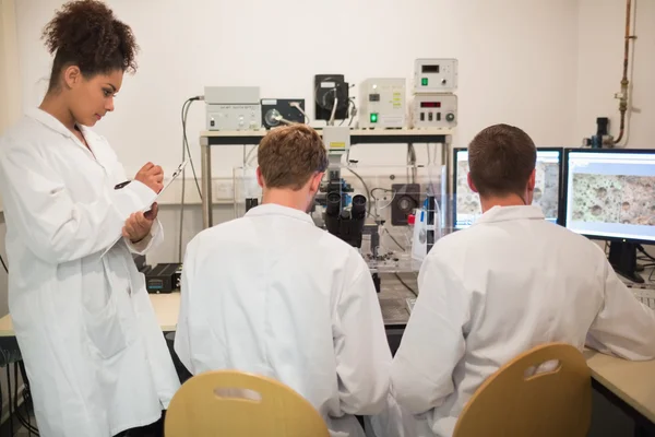 Студенты-биохимики используют большой микроскоп — стоковое фото