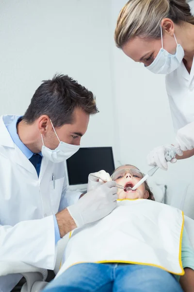 Dentista masculino con asistente examinando los dientes de las niñas —  Fotos de Stock