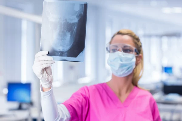 Dentysta w maski i okularów ochronnych, trzymając x-ray — Zdjęcie stockowe