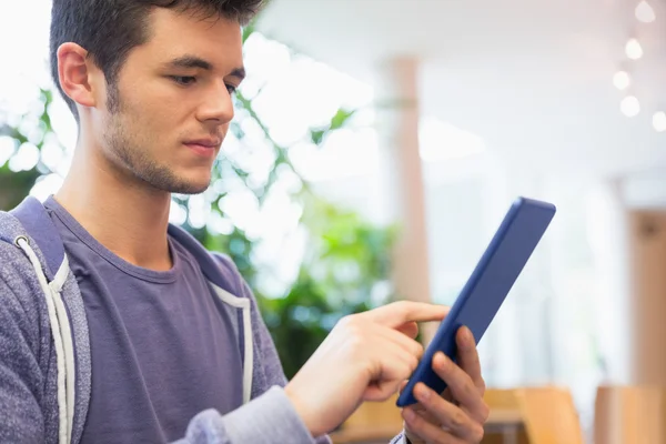 Ung student med sin tablett i café — Stockfoto