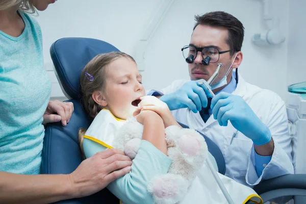 Dentista examinando dentes meninas com assistente — Fotografia de Stock