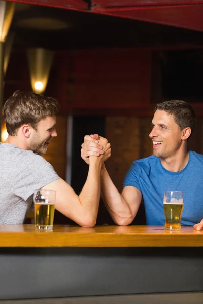 Happy friend arm wrestling each other — Stock Photo, Image