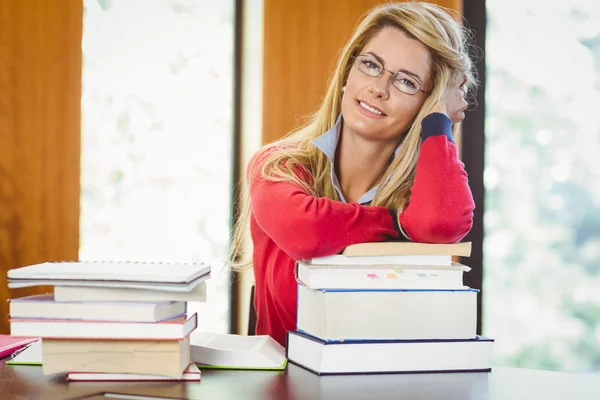 Uśmiechający się dojrzały student z stos książek — Zdjęcie stockowe