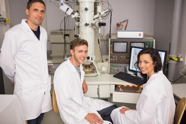 Estudiantes de bioquímica usando microscopio grande — Foto de Stock