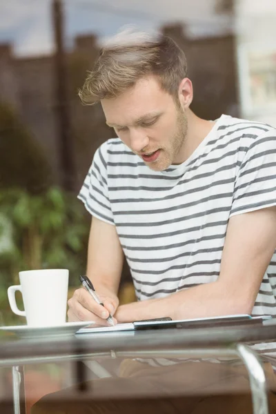 Usměvavý student sedí s horkým nápojem — Stock fotografie