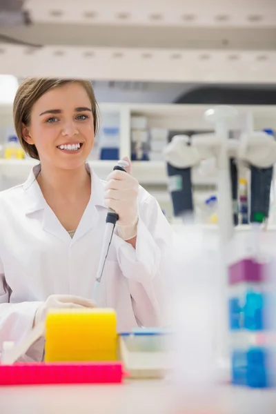 Jolie étudiante en sciences utilisant une pipette — Photo