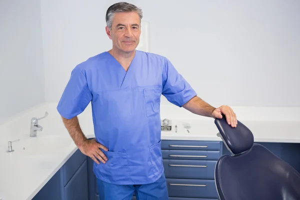 Portrait of a friendly dentist near dentists chair — Stock Photo, Image