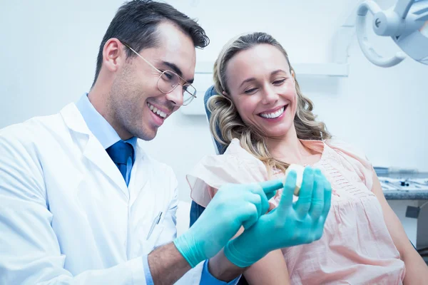 Male dentist teaching woman how to brush teeth — Stock Photo, Image