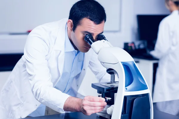 Estudante de ciência olhando através do microscópio — Fotografia de Stock