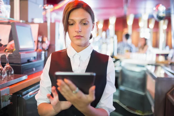 Barmanka koncentruje się przy użyciu ekranu dotykowego do — Zdjęcie stockowe