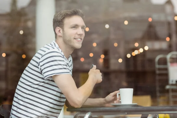 Lächelnder Student sitzt mit einem heißen Getränk — Stockfoto