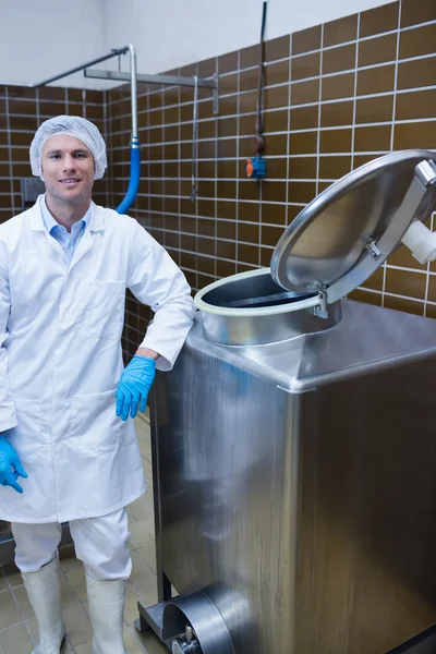 Smiling biologist leaning against storage tank — Stock Photo, Image