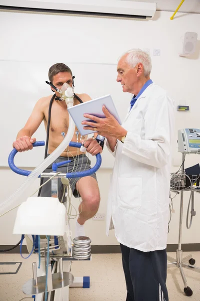 Médico mostrando tableta PC al hombre haciendo la prueba de aptitud —  Fotos de Stock