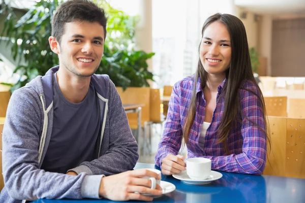 Unga studenter ler mot kameran i café — Stockfoto