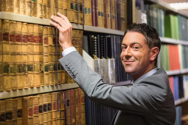 Advocaat plukken boek in de law library — Stockfoto