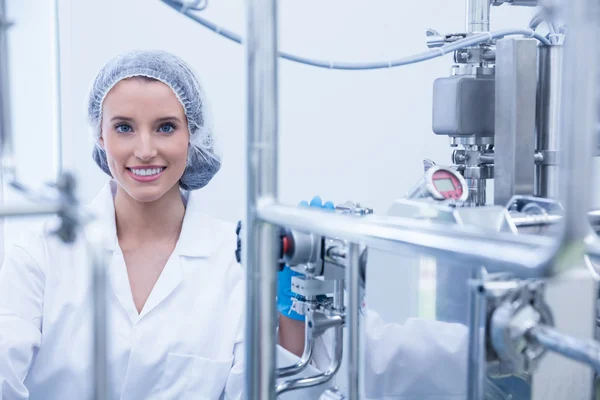 Retrato de un científico sonriente detrás de una tubería metálica — Foto de Stock