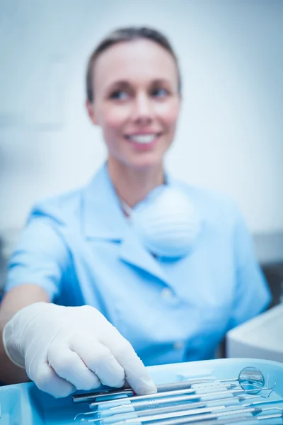 Dentista femenina recogiendo herramientas dentales —  Fotos de Stock