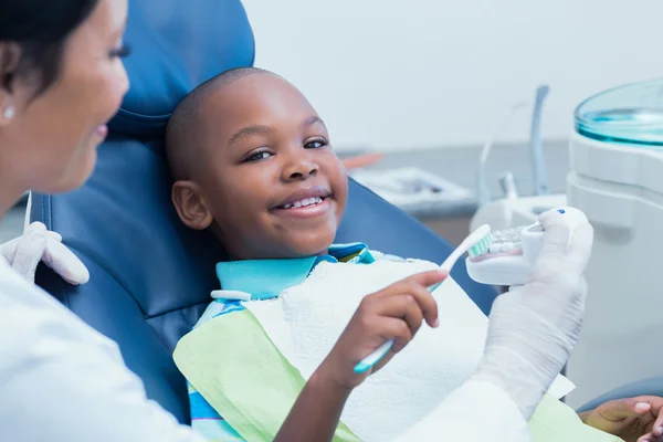 Dentist teaching happy boy — Stock Photo, Image