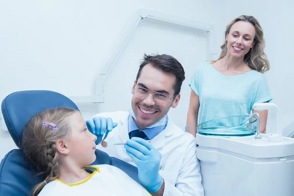 Dentista examinando los dientes de las niñas con asistente — Foto de Stock