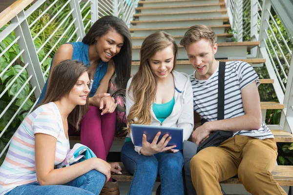 Estudantes sorridentes sentados em passos com tablet pc — Fotografia de Stock