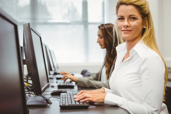 Glückliche Frau im Computerraum lächelt in die Kamera — Stockfoto