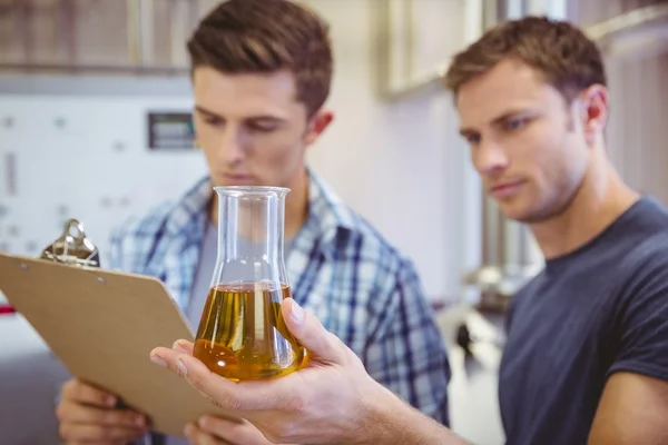 Due uomini che guardano il becher con la birra — Foto Stock