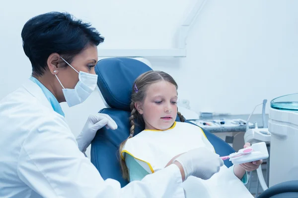 Kobieta dentysty nauczania dziewczyna jak szczotkować zęby — Zdjęcie stockowe