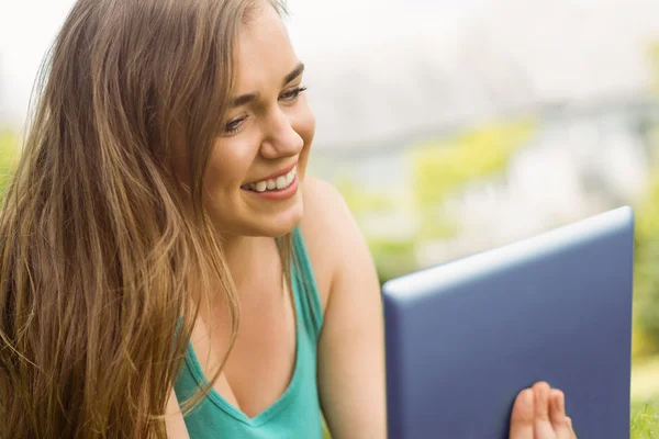 Sorridente studente universitario sdraiato e utilizzando tablet pc — Foto Stock