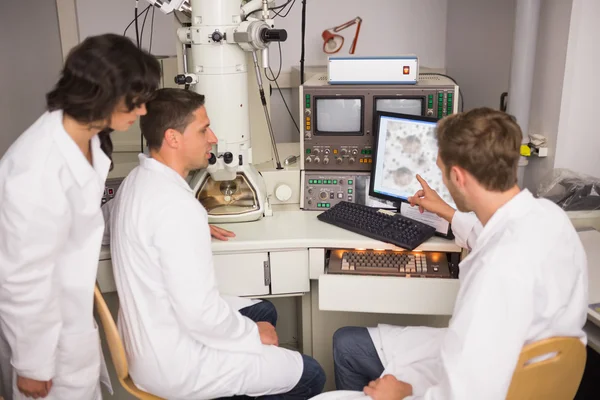 Estudantes de bioquímica usando microscópio grande — Fotografia de Stock