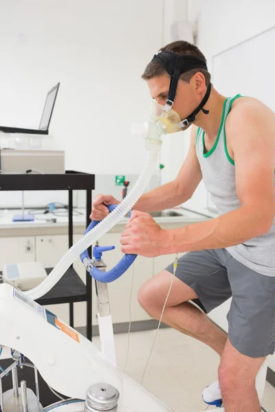 Hombre haciendo la prueba de aptitud en bicicleta estática —  Fotos de Stock