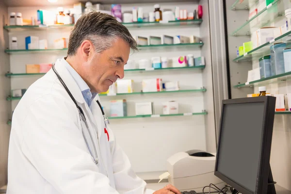 Gerichte apotheker using naar de computer — Stockfoto