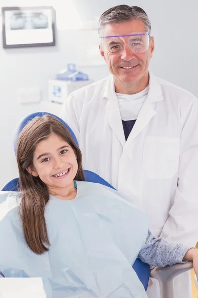 Lächelnder Zahnarzt mit Schutzbrille und glücklicher junger Patient — Stockfoto