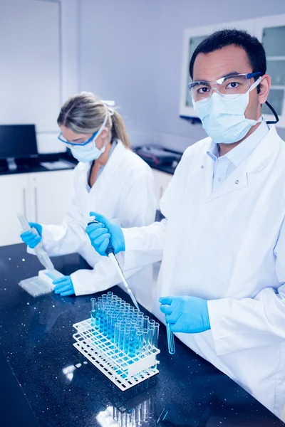 Estudantes de ciências usando pipetas para encher tubos de teste — Fotografia de Stock