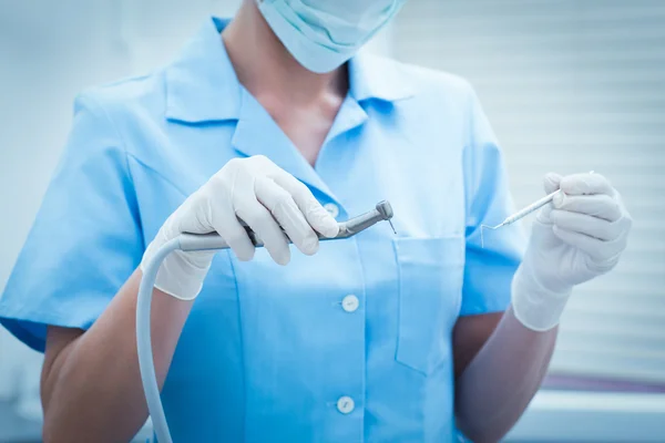 Средняя часть стоматолога держит стоматологические инструменты — стоковое фото
