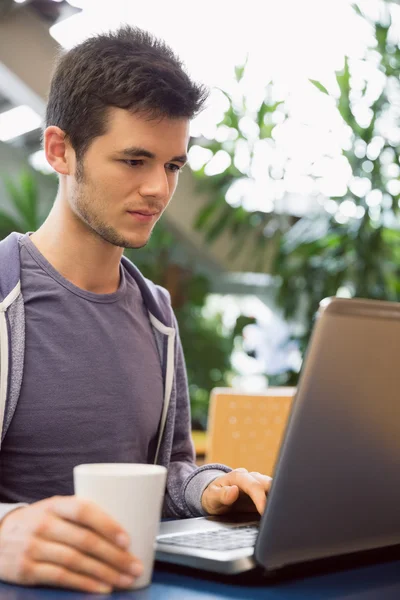 Νεαρός φοιτητής χρησιμοποιώντας το laptop στο καφέ — Φωτογραφία Αρχείου
