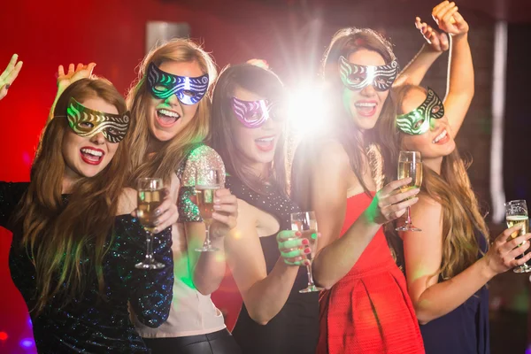 Friends in masquerade masks drinking champagne — Stock Photo, Image