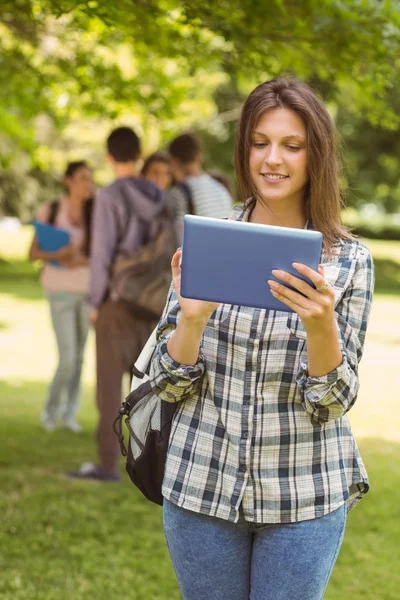 Glimlachend student met een schoudertas en met behulp van tablet pc — Stockfoto