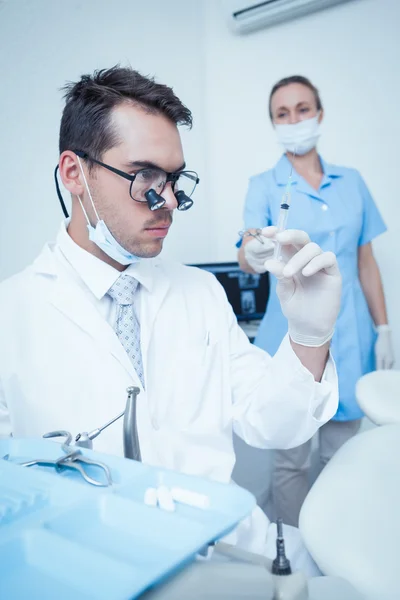 Dentist looking at injection — Stock Photo, Image