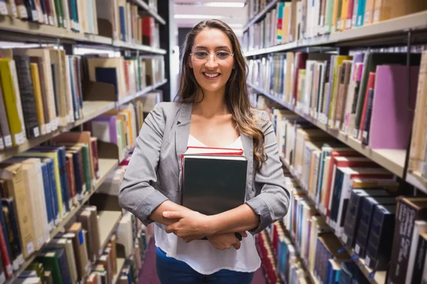 Estudante bonito escolhendo um livro na biblioteca — Fotografia de Stock