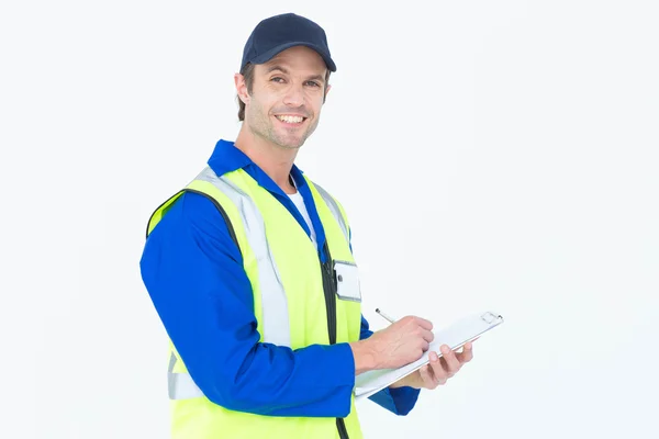 Handsome supervisor writing notes on clipboard — Stock Photo, Image